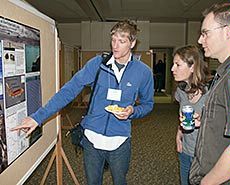 a student and attendees at a poster session