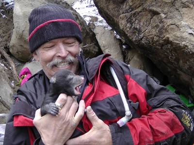 A person holds a baby animal in their arms.