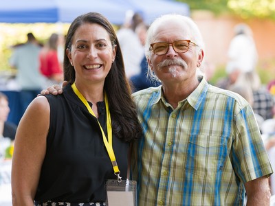 A man and a woman pose for a photo at a dinner.