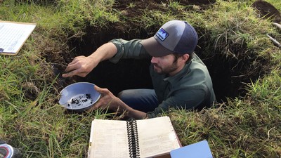 Ryan Hodges studies soils in the ground.