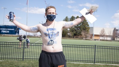 A man wears body paint depicting USU mascot Big Blue.
