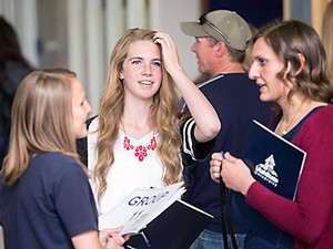 A USU group guide with a parent and student at USU's 2015 Scholars Day