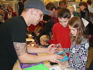 a scientist shows spiders to children at Science Unwrapped