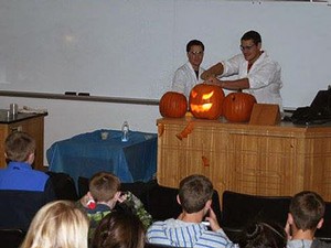 USU students providing a hands-on demonstration with a pumpkin