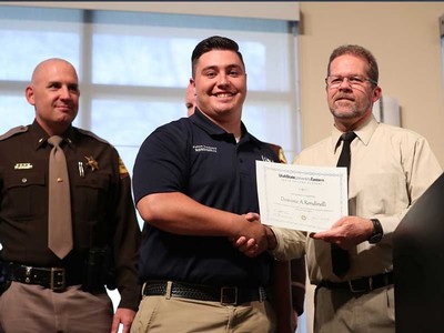 Dominic Rondinelli accepts his Peace Officer Standards Training (POST) certificate from Scott Henrie