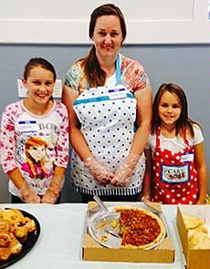 a mother and her two daughters volunteering at Loaves and Fishes
