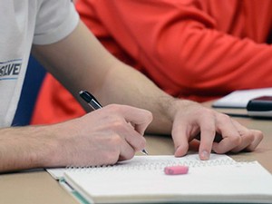 photo illustration, student in a classroom taking notes