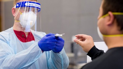 Medical professional testing at USU student for COVID-19.