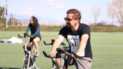 USU student rides a spin bike in Aggie Rec's Triathlon.