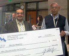 USU grad student Morris Dmitry and faculty mentor Michael McFarland with check
