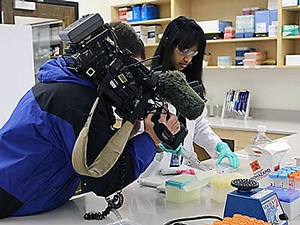 A USU graduate student and KSL camerman in the Institute for Antiviral Research lab