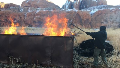 A firefighter from the Lone Peak Engine Crew tends a big box kiln.