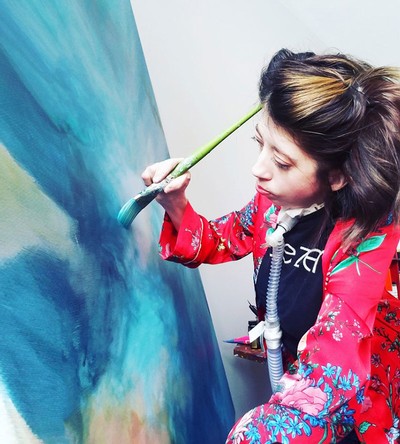 Kelie Hess, visual artist, works on one of her paintings.