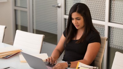 woman sitting at a desk and using a computer.