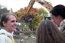 spectators watch house demolition