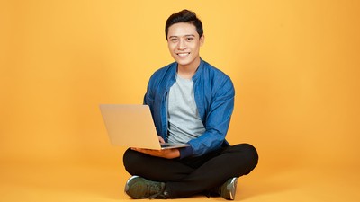 A young man with a laptop.