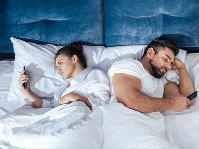 couple in bed on their mobile phones.