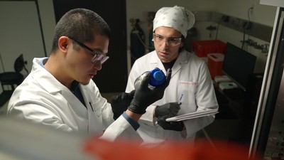 Two scientists inspecting a container.