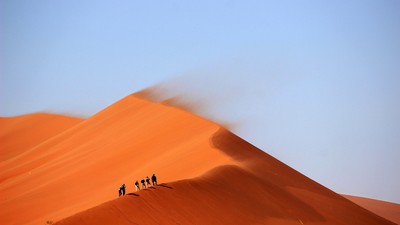 Hikers traversing a landscape.