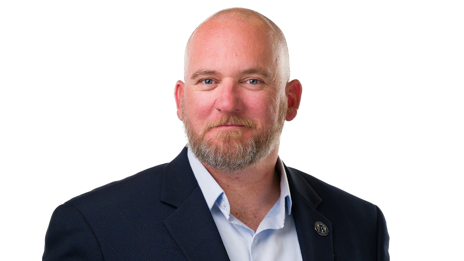 A man poses for a photo with a white background.