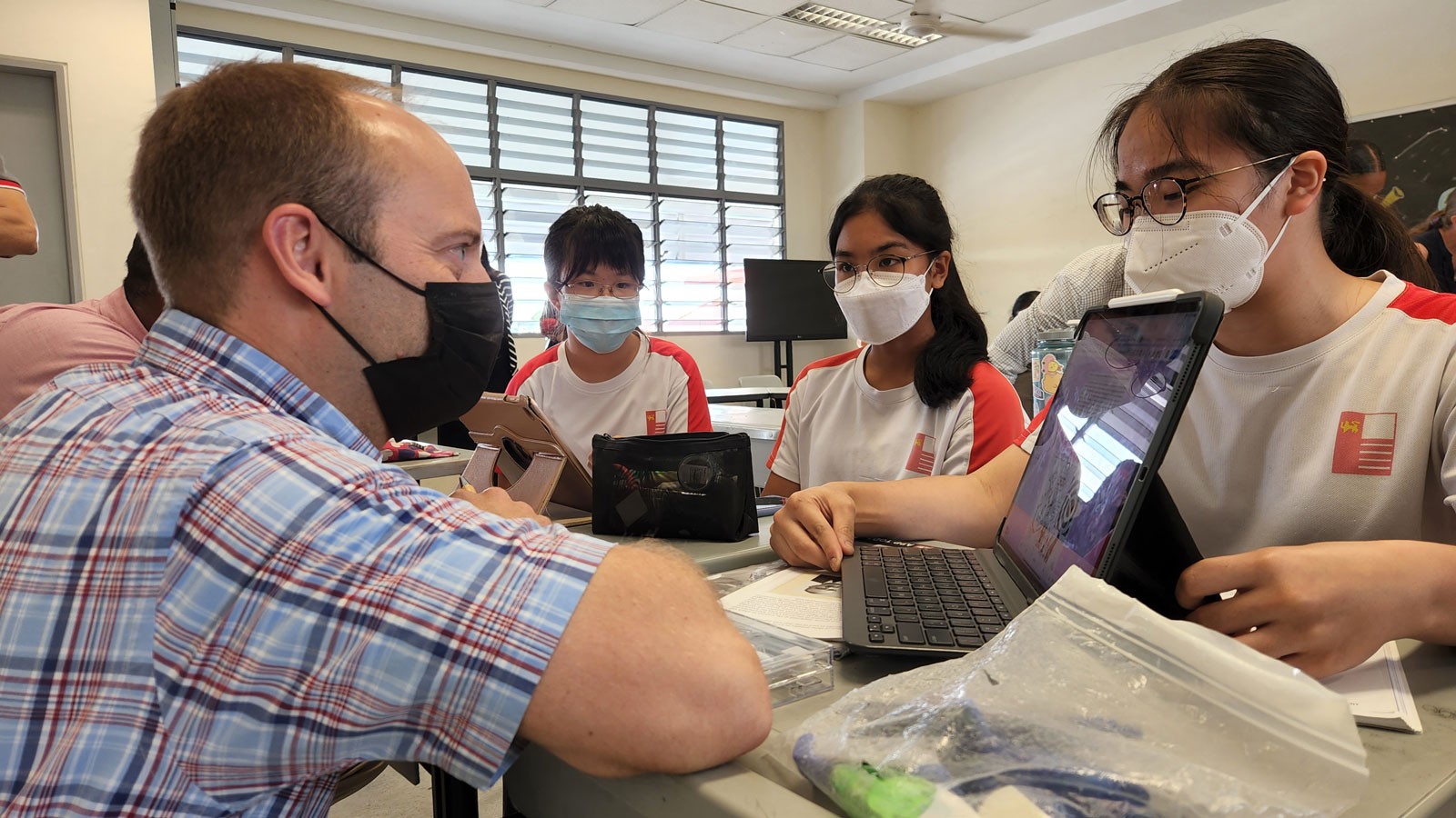 Students showing an educator their tablet computers.