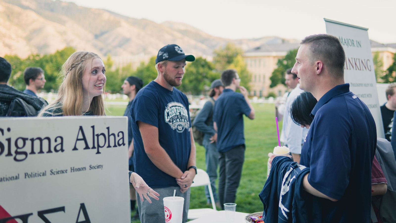People converse at a Pi Sigma Alpha informational booth on the Quad.