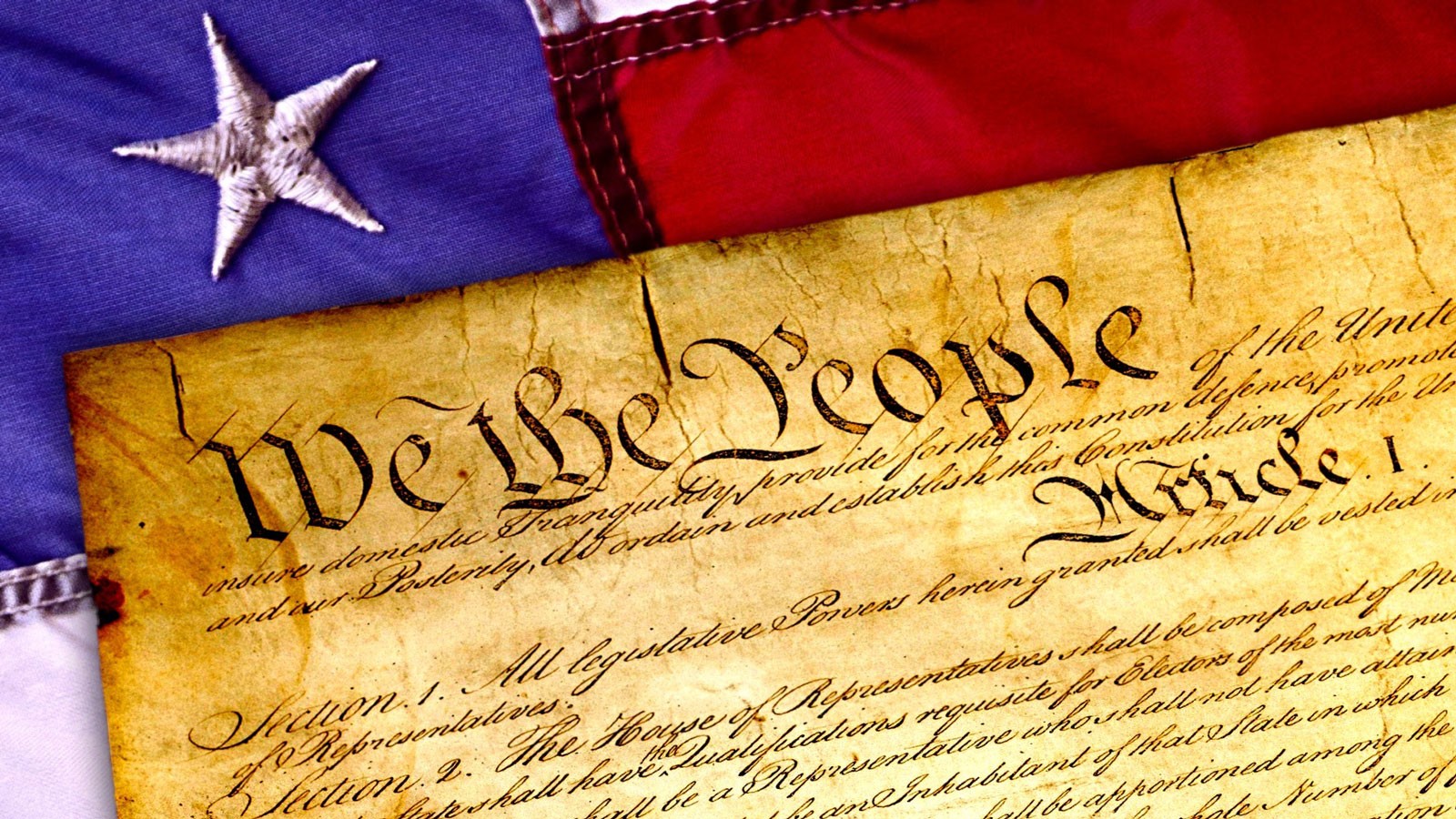An illustration of the U.S. Constitution placed over an American flag.