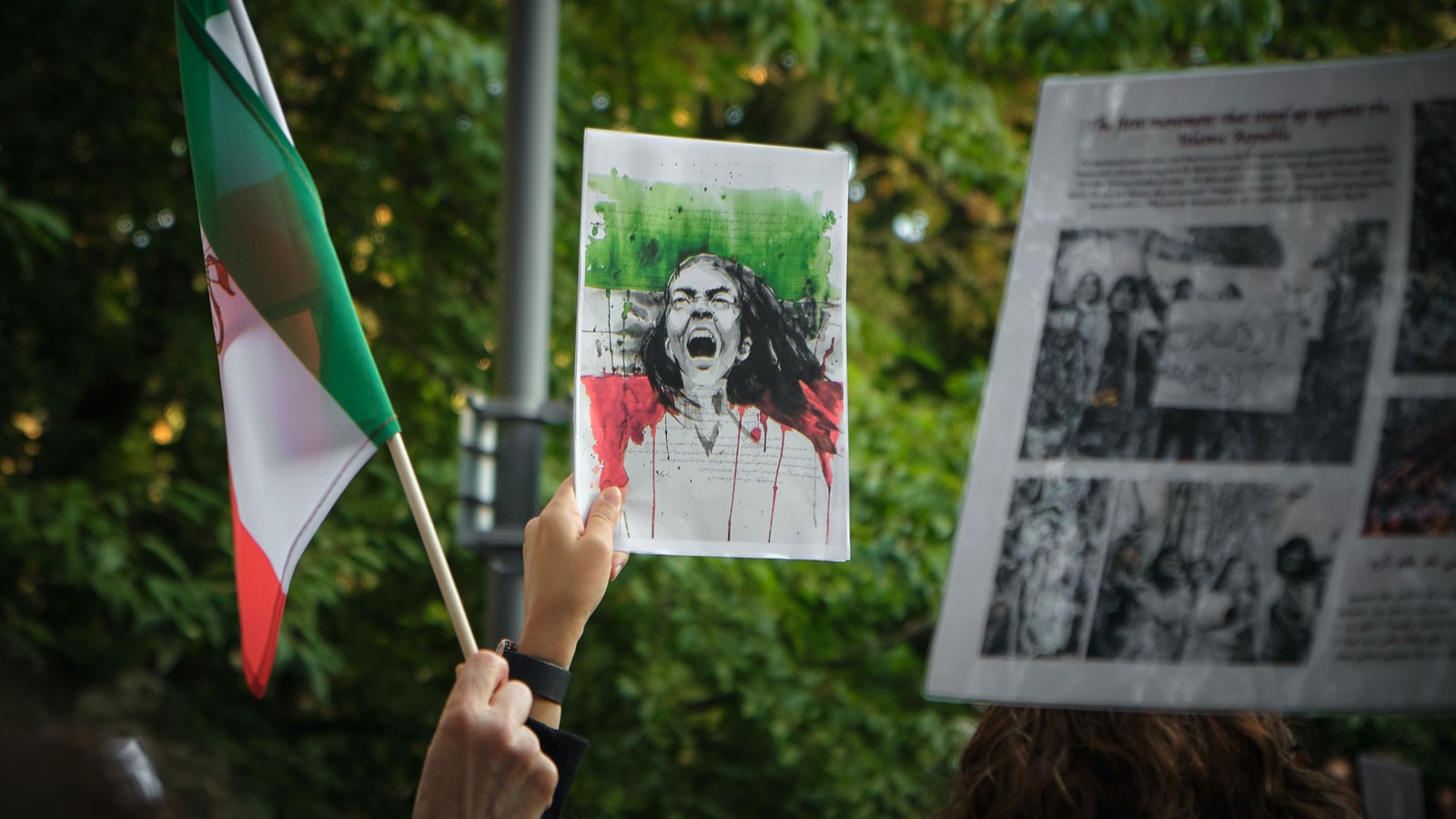 People holding flags and posters at a protest.
