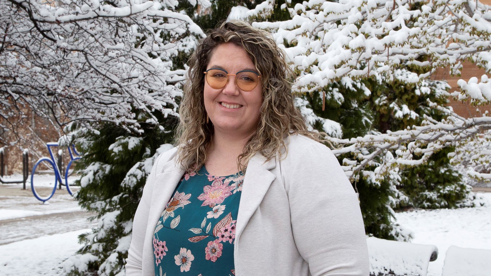 Cassandra McCall stands in front of a snowy tree on the USU Logan campus.