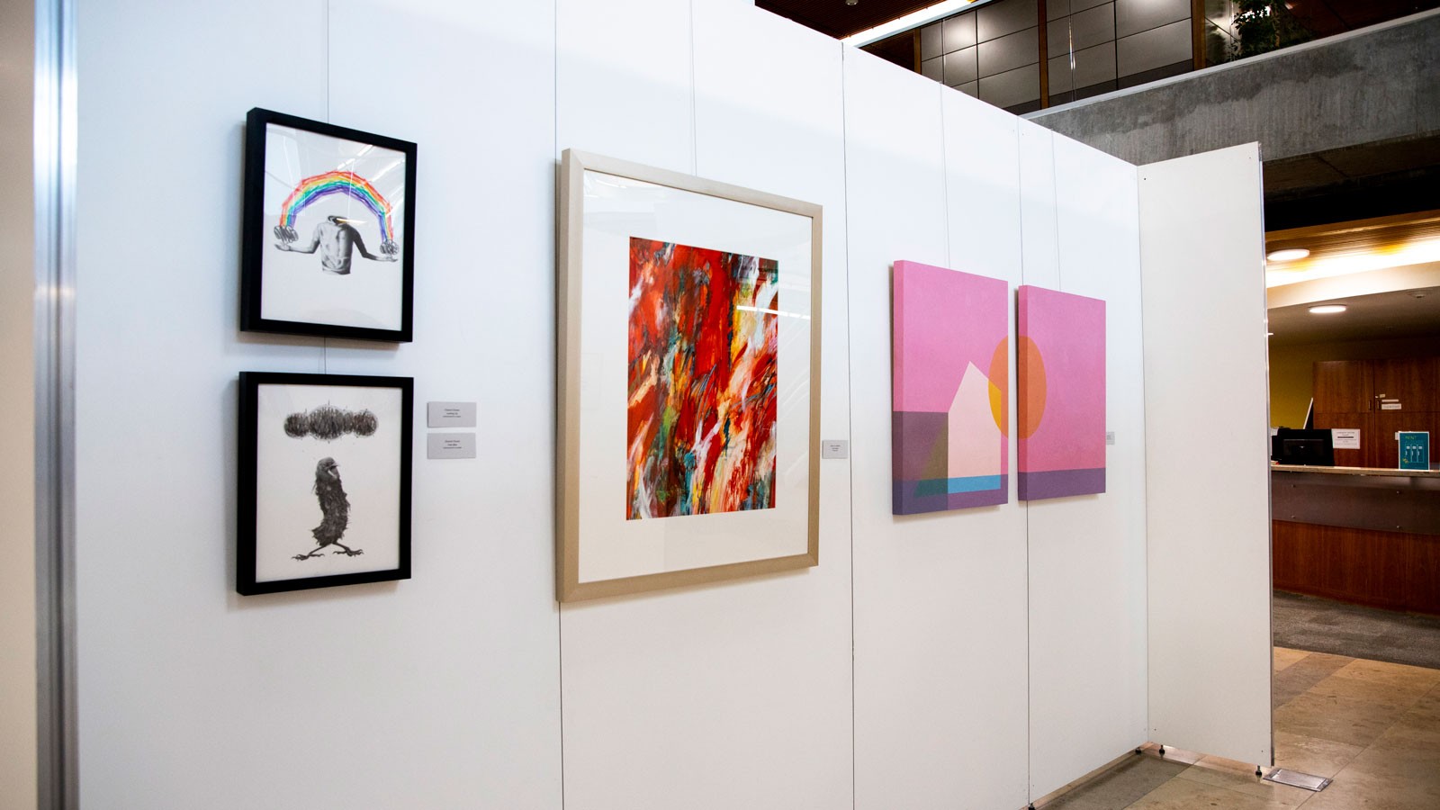 Paintings hang on an exhibit wall at the Merrill-Cazier Library at USU in Logan.
