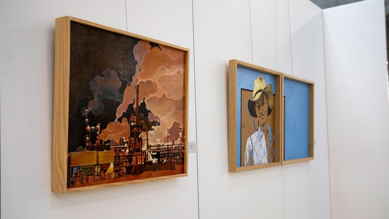 Paintings hang on an exhibit wall at the Merrill-Cazier Library at USU in Logan.