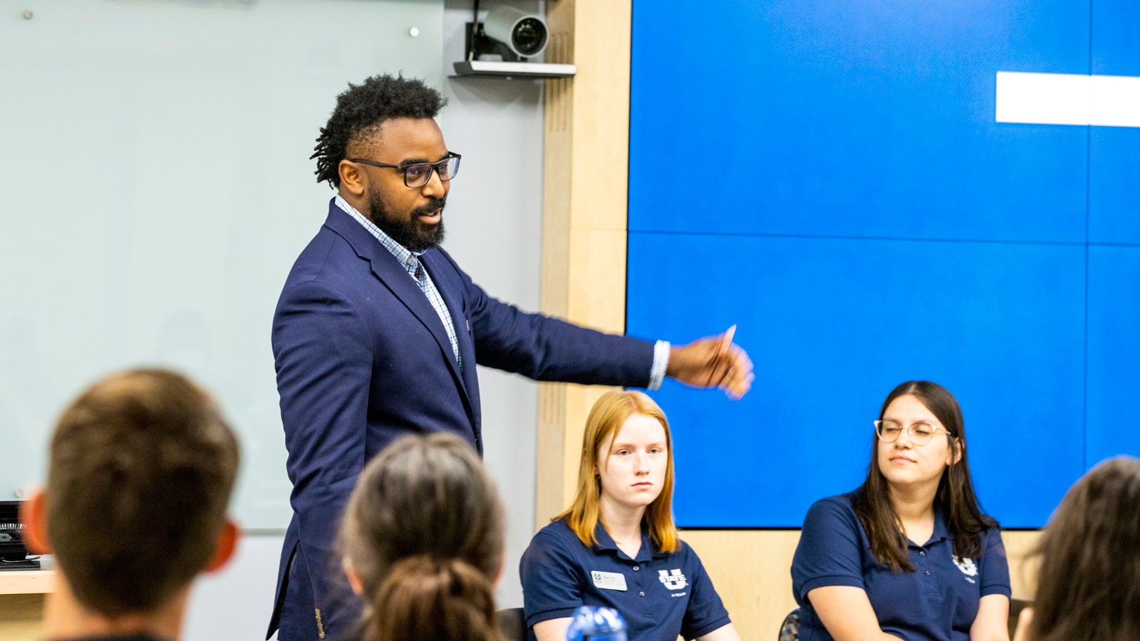 Isaiah Jones speaks to others in a conference room.
