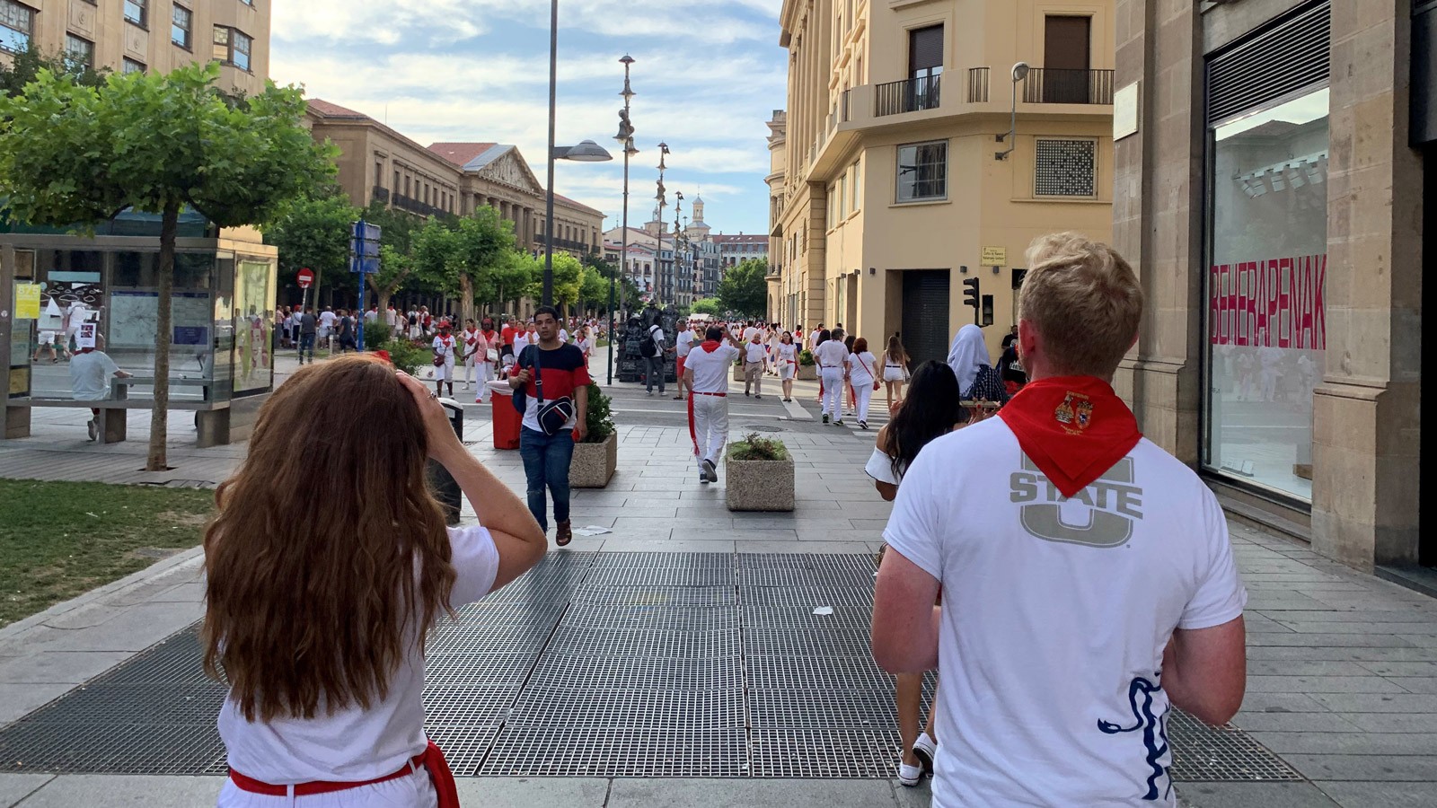 Two students walking on a street in Spain.