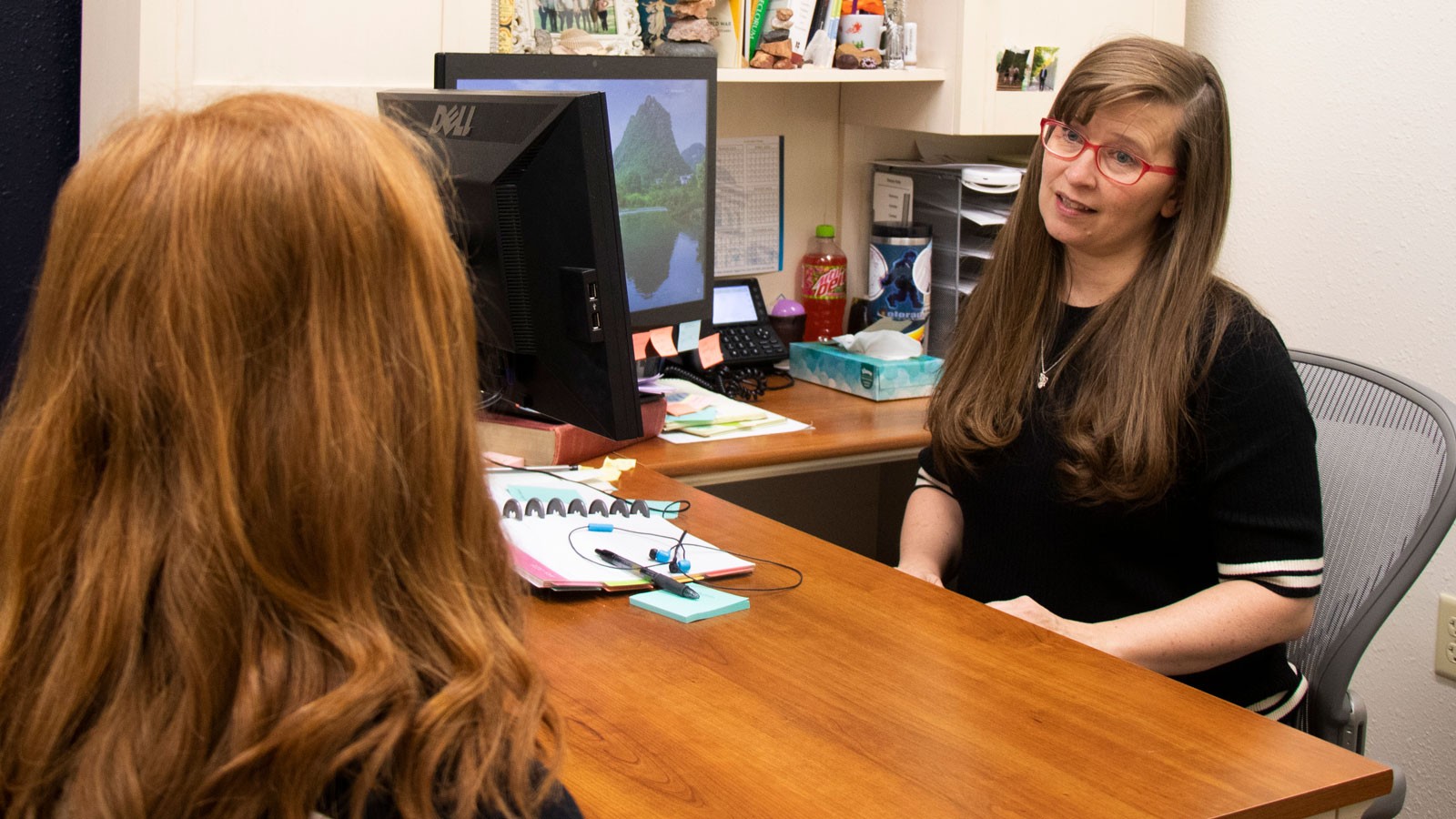 Stacey Kelly talks with a student in her office