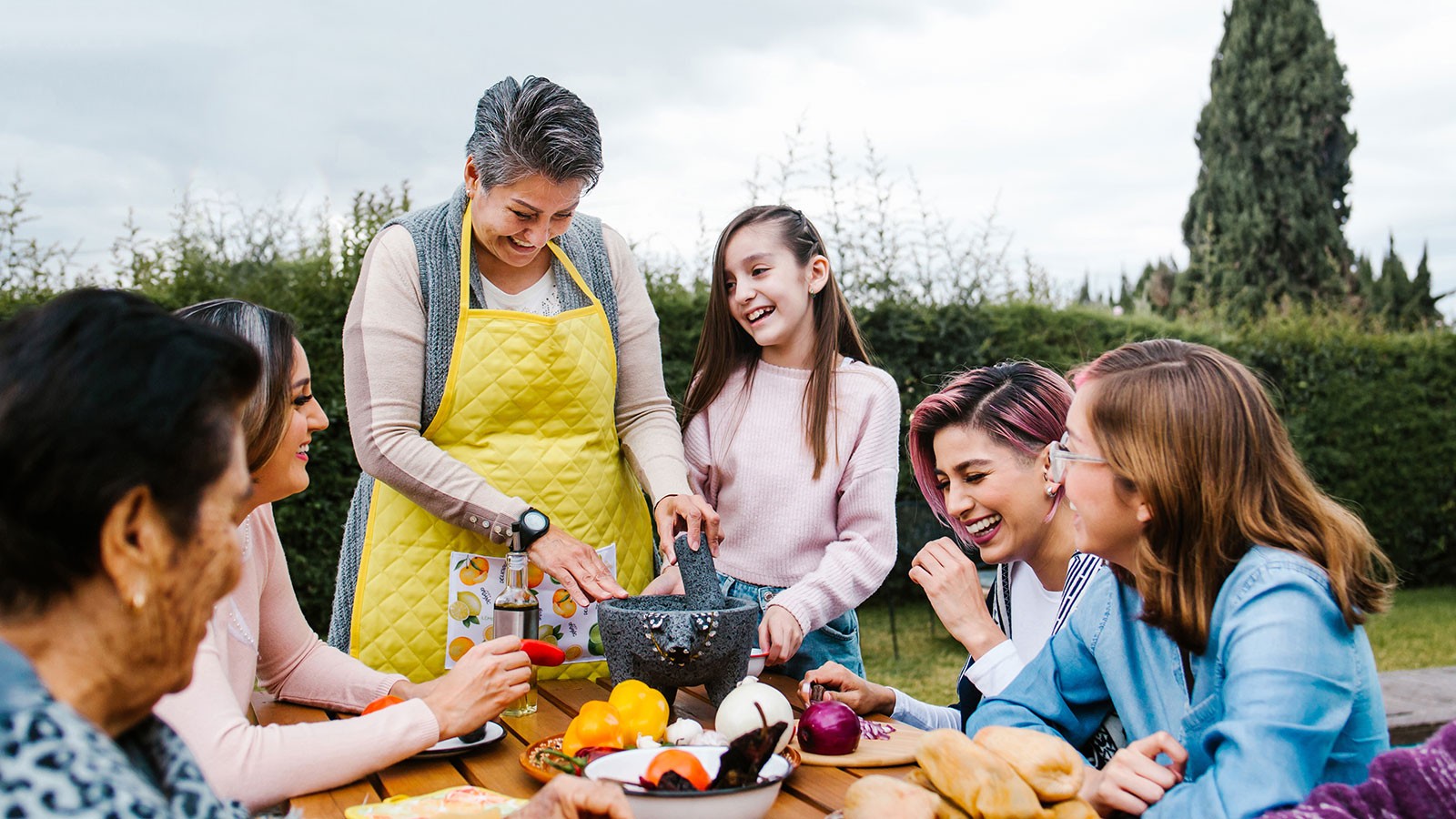 Women sit around a picnic table for a meal.