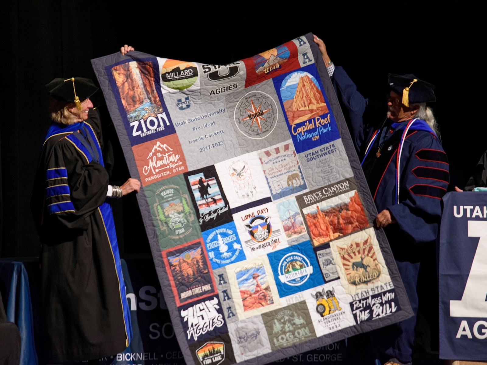 A person holds up a quilt