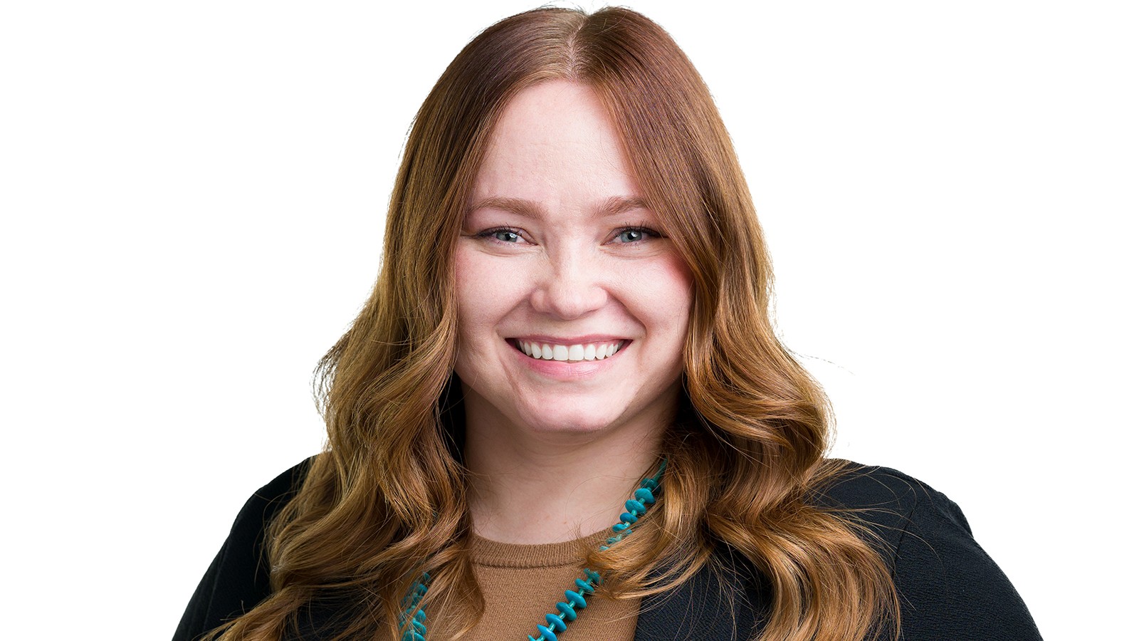 A woman poses for a photo against a white background.
