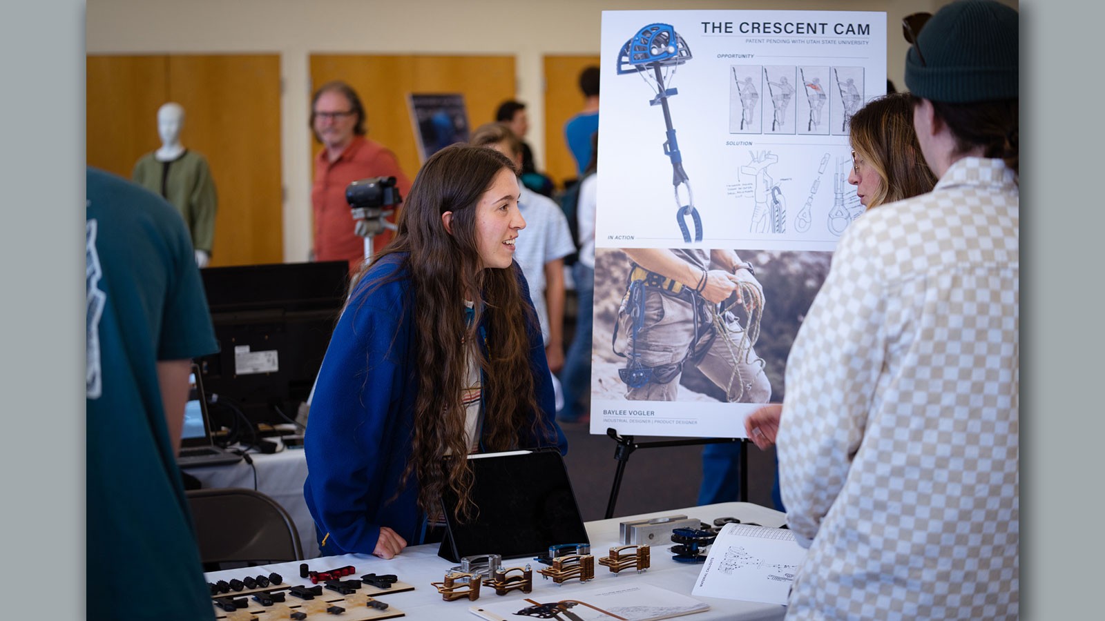 Baylee Volger explaining a rock climbing device she designed.