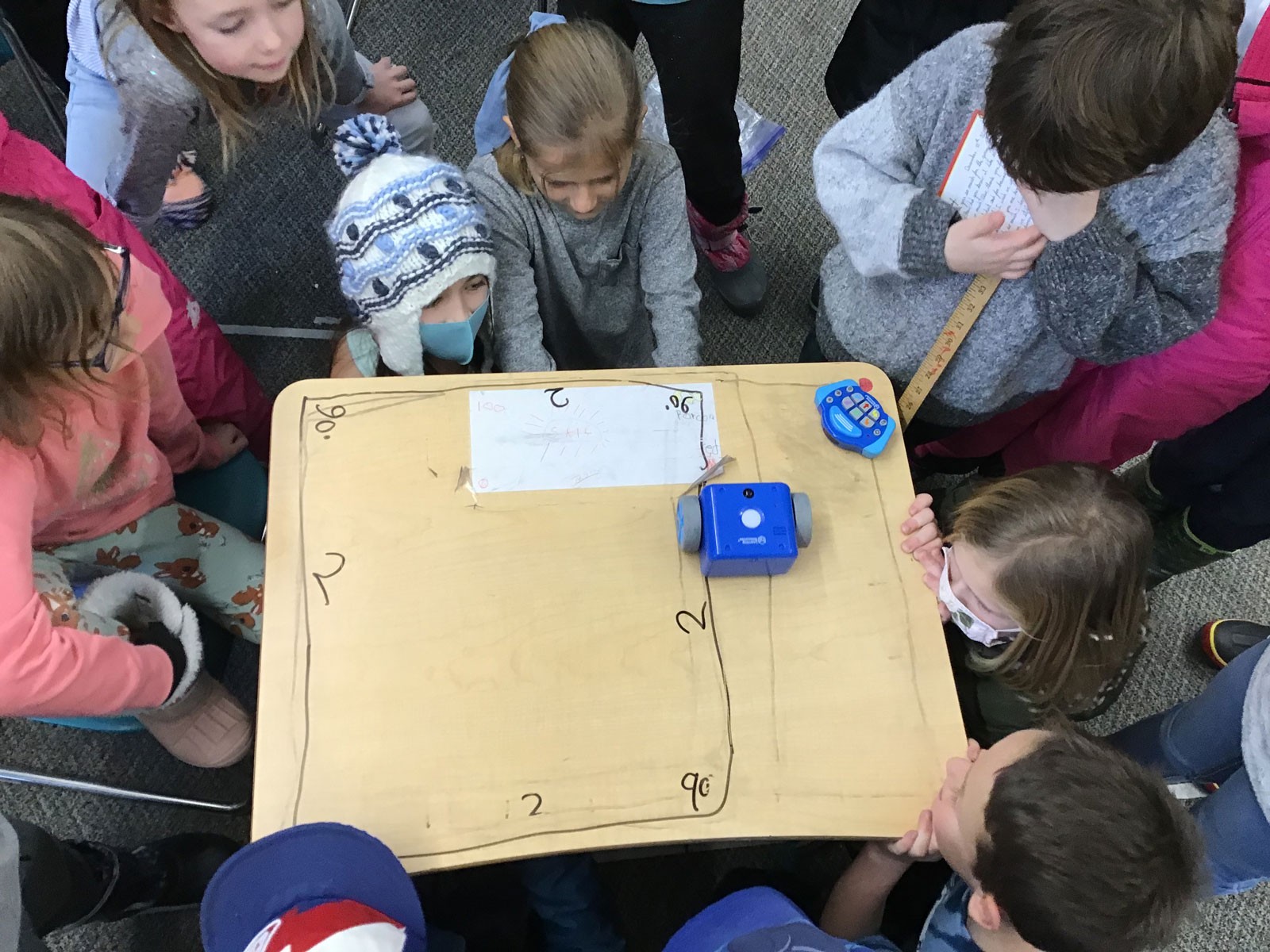 Children around a table with robotics equipment.