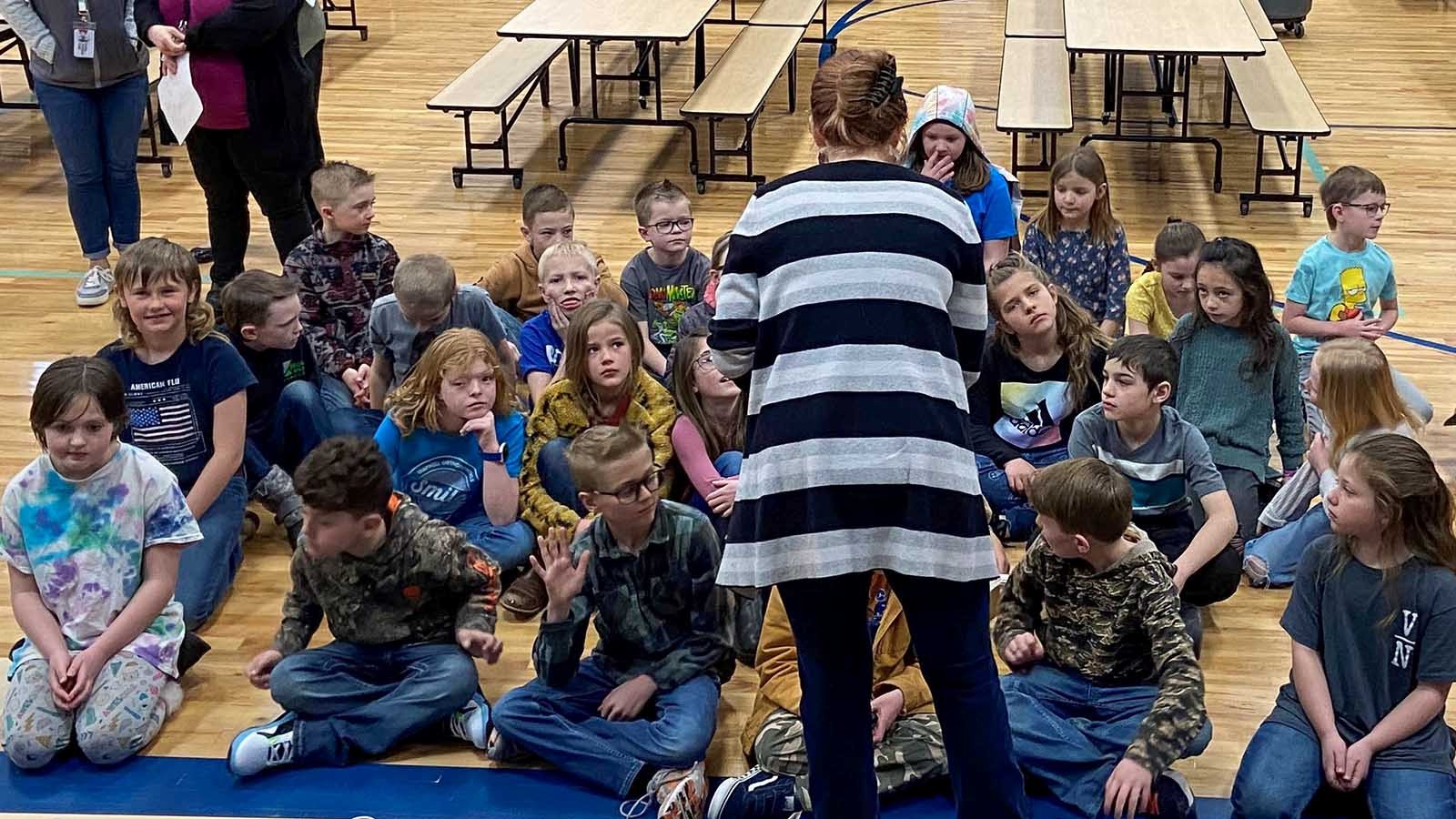 K-12 students listen to an engineering student.
