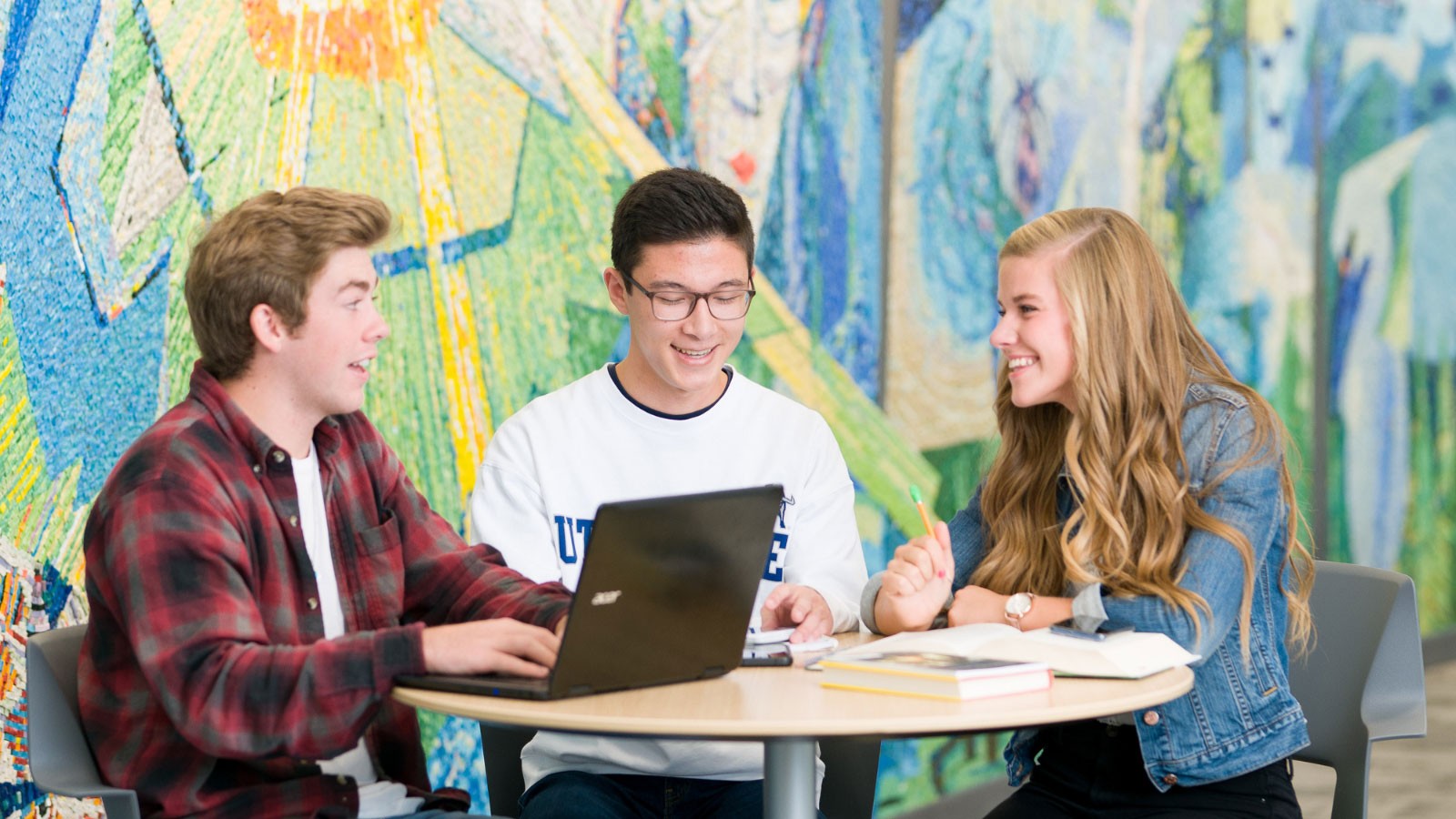 Students studying with textbooks and laptops.