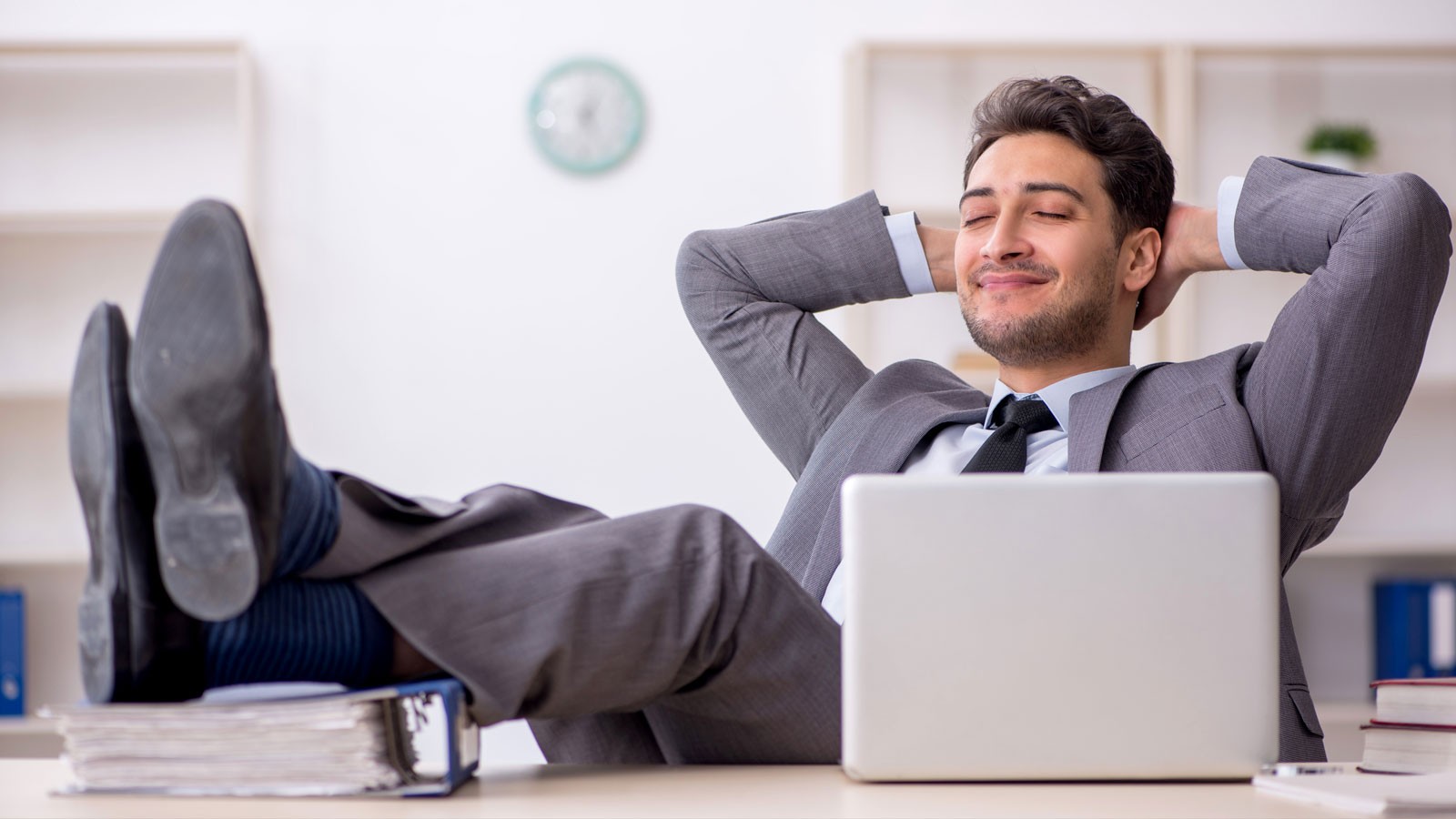 A worker reclining at a desk.