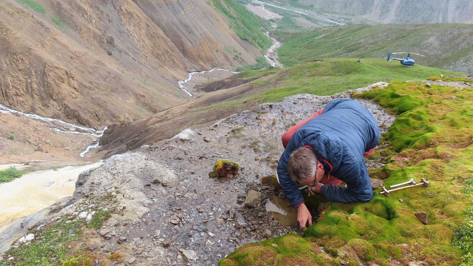 A geochemist working at a mountainside spring.
