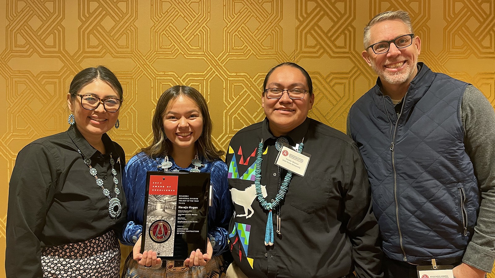 Students and faculty stand with an award.