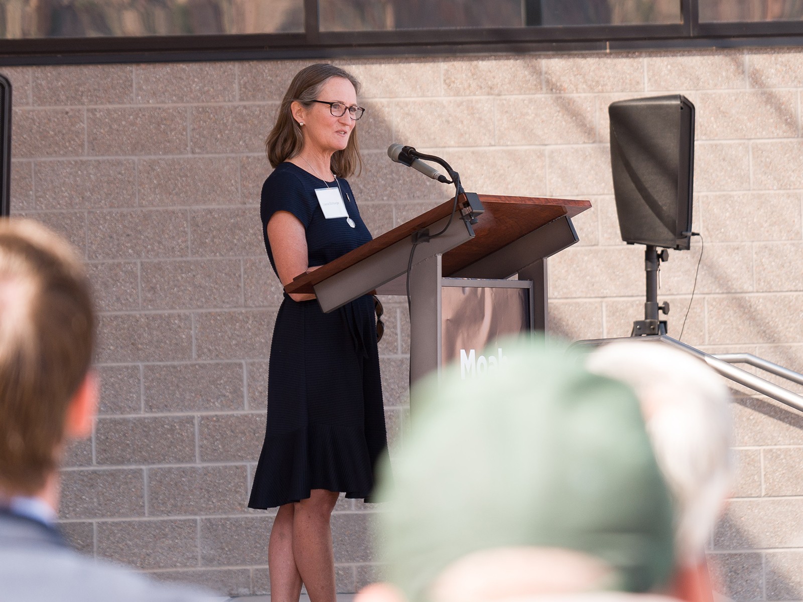 A woman stands at a pulpit to address a crowd.