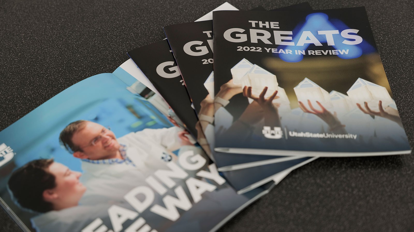 Magazines on a table. Text reads: "The Greats: 2022 Year in Review."