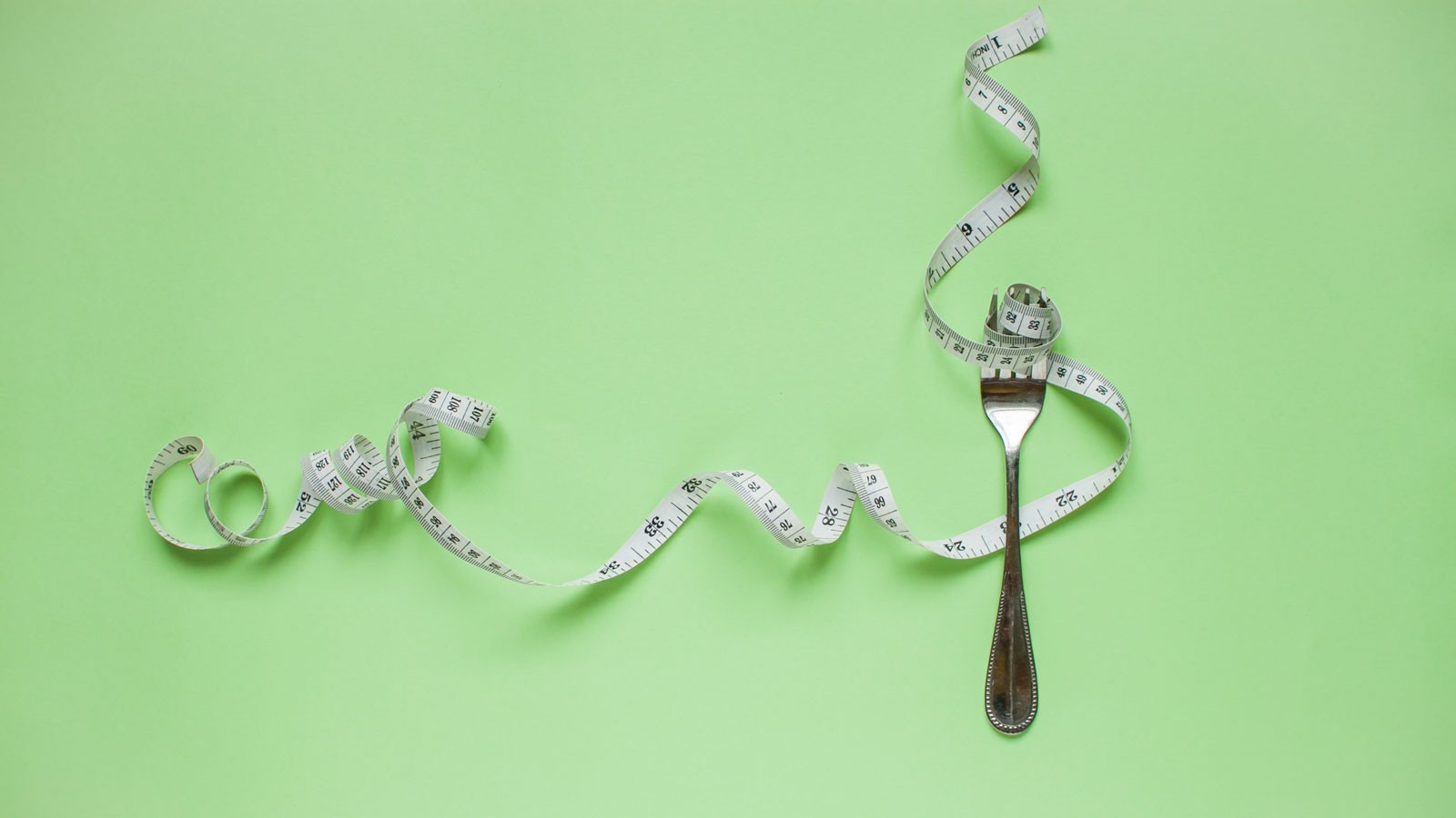 A photo illustration of a flexible measuring tape spiraling around a fork.