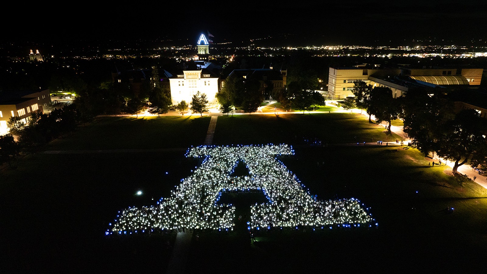 Students stand in a formation to create an A at the annual luminary event