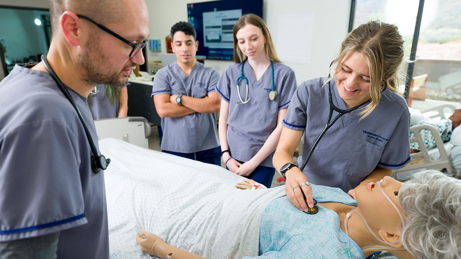 A USU nursing student practices using a stethoscope on a manikin.