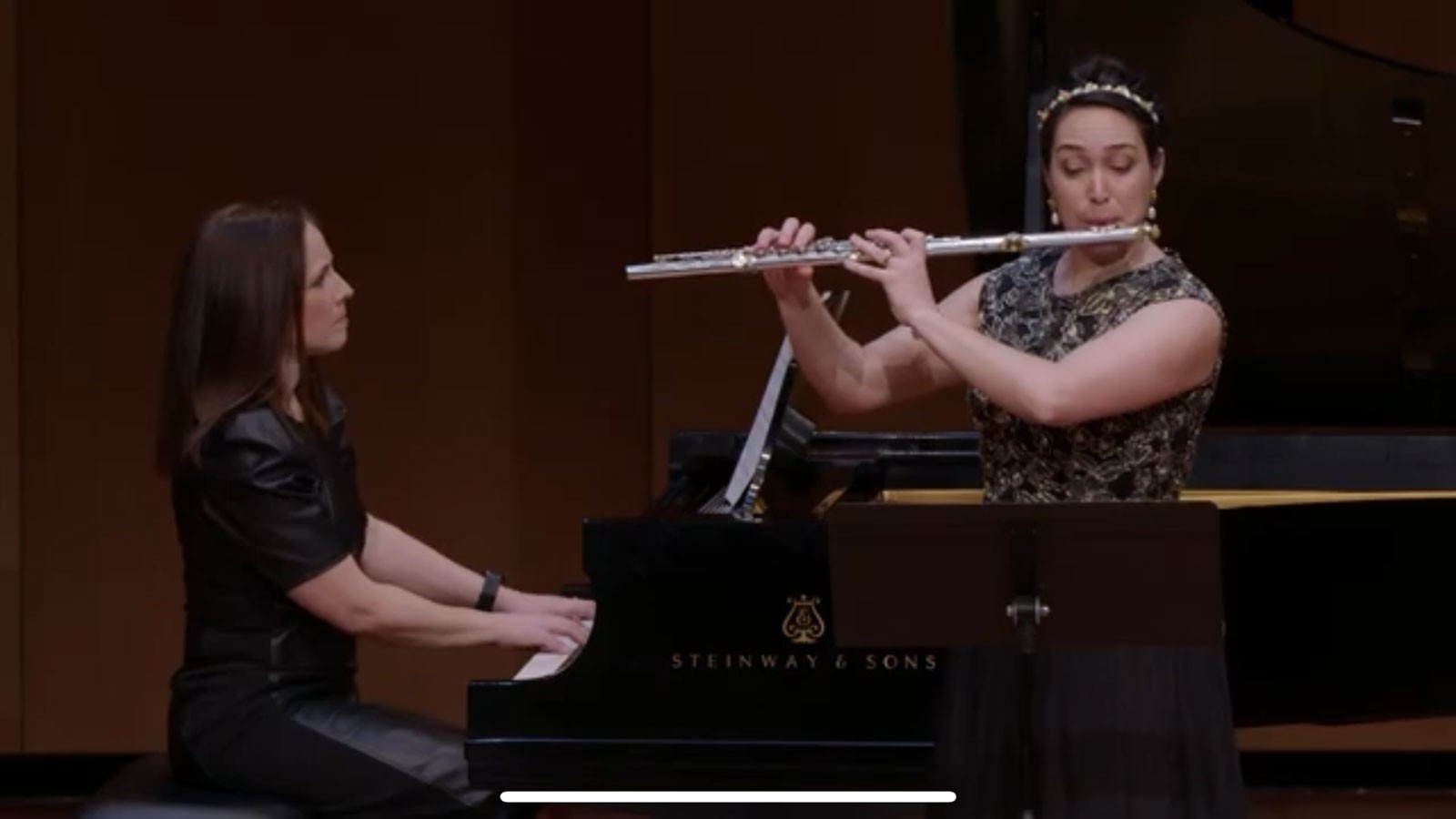 A person playing the piano and a person playing the flute.
